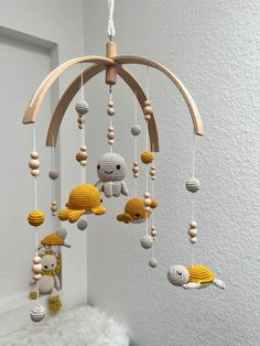 a crocheted mobile with stuffed animals hanging from it's sides in a white room