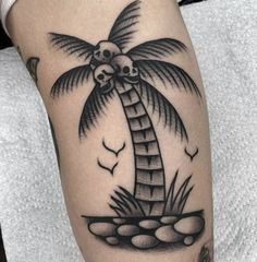 a black and white palm tree with skulls on it's head is shown in this tattoo