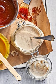 various sauces and condiments sit on a wooden table with utensils