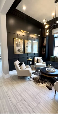 a living room filled with white furniture and black walls