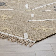 a beige rug with blue and white designs on the top is laying on a wooden floor