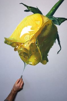 a person is holding a yellow flower in the air