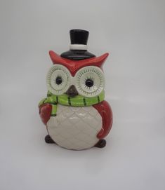 an owl figurine with a top hat and scarf on it's head