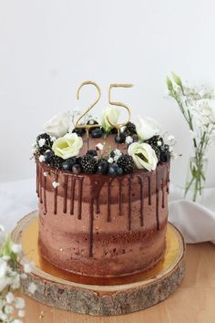 a chocolate cake with berries and flowers on top