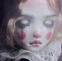 a close up of a doll's face with blood on her eyes and nose