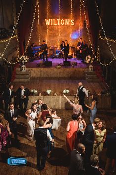 a group of people standing on top of a wooden floor in front of a crowd