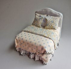 a bed with two pillows on top of it next to a pillow case and blanket