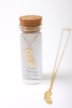 a small bottle with a gold necklace on it