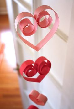 an image of a heart mobile hanging from the ceiling with paper hearts attached to it