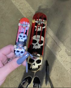 someone is holding a skateboard with skulls on it and the bottom part has been painted