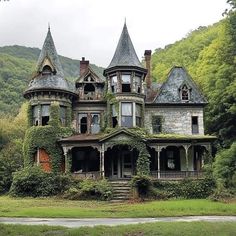 an old house with ivy growing all over it's roof and windows, surrounded by mountains