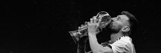 a black and white photo of a man drinking from a water bottle in the rain