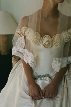 a woman in a wedding dress sitting down