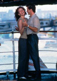 a man and woman dancing on the deck of a boat