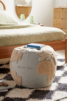 a bedroom with a bed, mirror and small stool on the floor in front of it