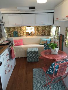 a small kitchen and living room in a trailer or camper with lots of furniture