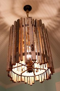 a chandelier made out of wooden planks hanging from the ceiling in a room