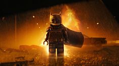 the lego batman movie character stands in front of a fire with his bat - mask on