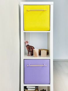 a white shelf with two drawers and a cat figurine on top