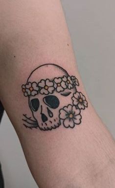 a skull with flowers on it's head is seen in this tattoo photo taken by the owner