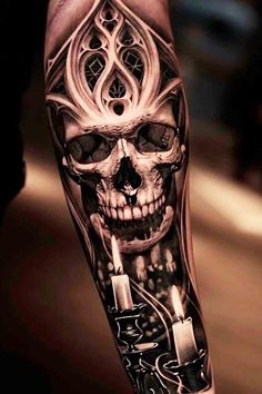 some tattoos that are on someone's arm and one has a skull in the middle