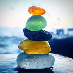 a stack of colorful rocks sitting on top of water