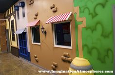 the inside of a children's playroom with painted walls and windows, including a door