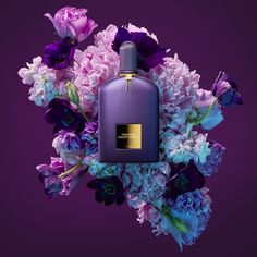 a purple bottle surrounded by flowers on a purple background