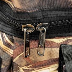 the zippers are attached to the back of a bag that is full of camouflage material