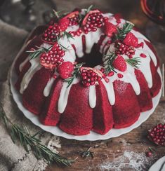 a red velvet bundt cake with white icing and berries