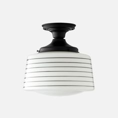 a black and white light hanging from a ceiling fixture with stripes on the bottom half of it