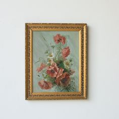 a painting hanging on the wall with flowers in it