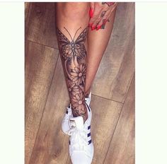 a woman's legs with tattoos and tennis shoes