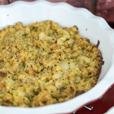 a casserole dish with potatoes and onions in it on a red tablecloth