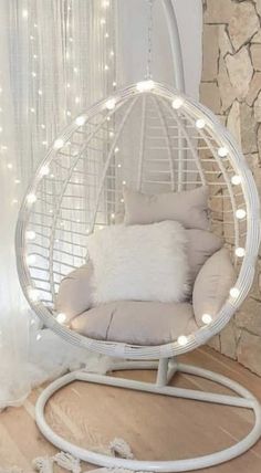 a white hanging chair with lights around it