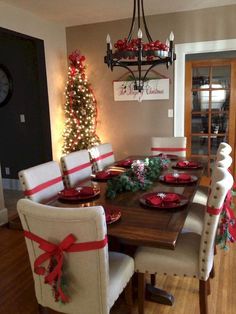 a dining room table decorated for christmas with red and white decorations