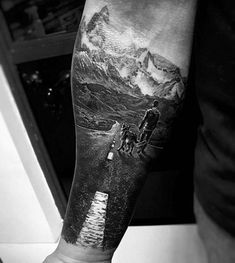 a man's arm with a mountain scene on it