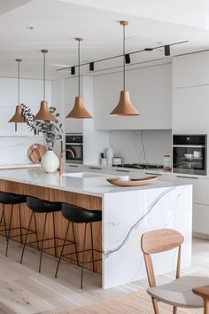 a kitchen with marble counter tops and wooden stools next to an island in the middle