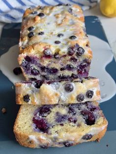 two slices of blueberry bread sitting on top of a plate next to lemons