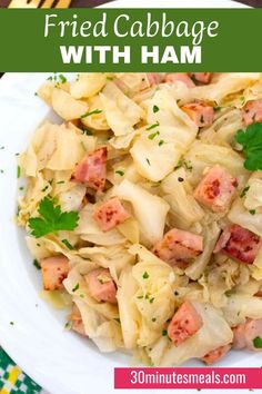 a white plate topped with cabbage and ham