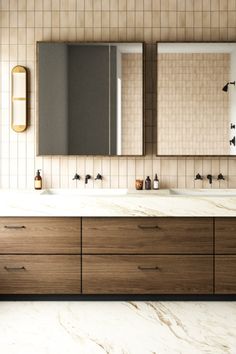 a bathroom with two sinks, mirrors and cabinets in the same color as the walls