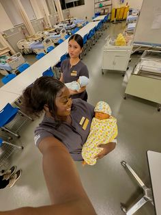 two women are holding a baby in a hospital