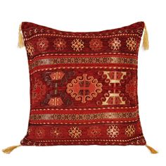 a red and gold decorative pillow with tassels