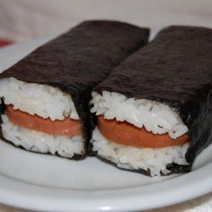 two pieces of sushi on a plate with white rice and carrots in it