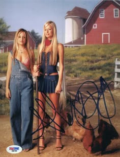 two young women standing next to each other in front of a farm with a chicken