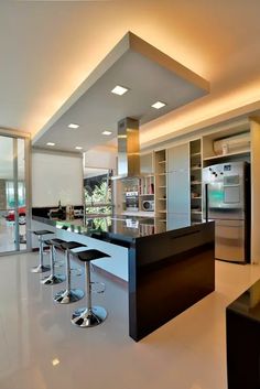 a modern kitchen with stainless steel appliances and black counter tops, along with white tile flooring