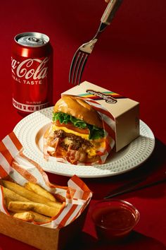 a plate with a sandwich and french fries on it next to a can of coca cola