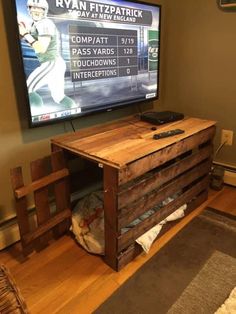 an entertainment center made out of pallets with a tv on the wall behind it