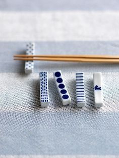 chopsticks and erasers sitting on top of a blue table cloth next to some chopsticks