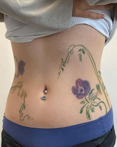 a woman's stomach with tattoos on it